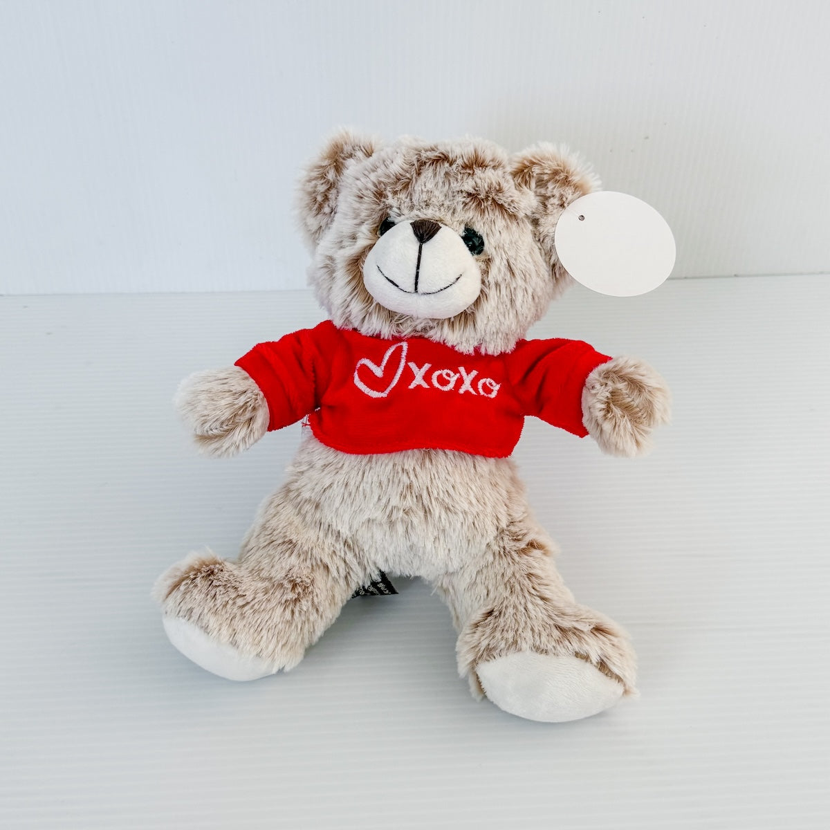 Teddy bear wearing a red shirt with 'XOXO' available to add-on to flowers or gift hampers.