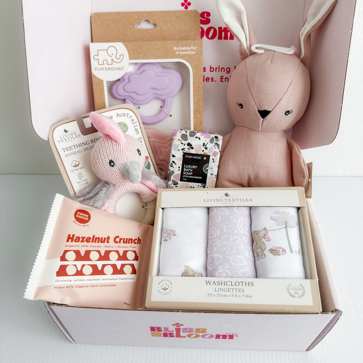 Hello Baby Girl Gift Hamper Filled With Chocolate, Luxury Bath Soap, a Bunny Soft Toy, Silicone Muslin Teether, Soft Rattle, and Milestone Cards For Same-Day Delivery Around Perth