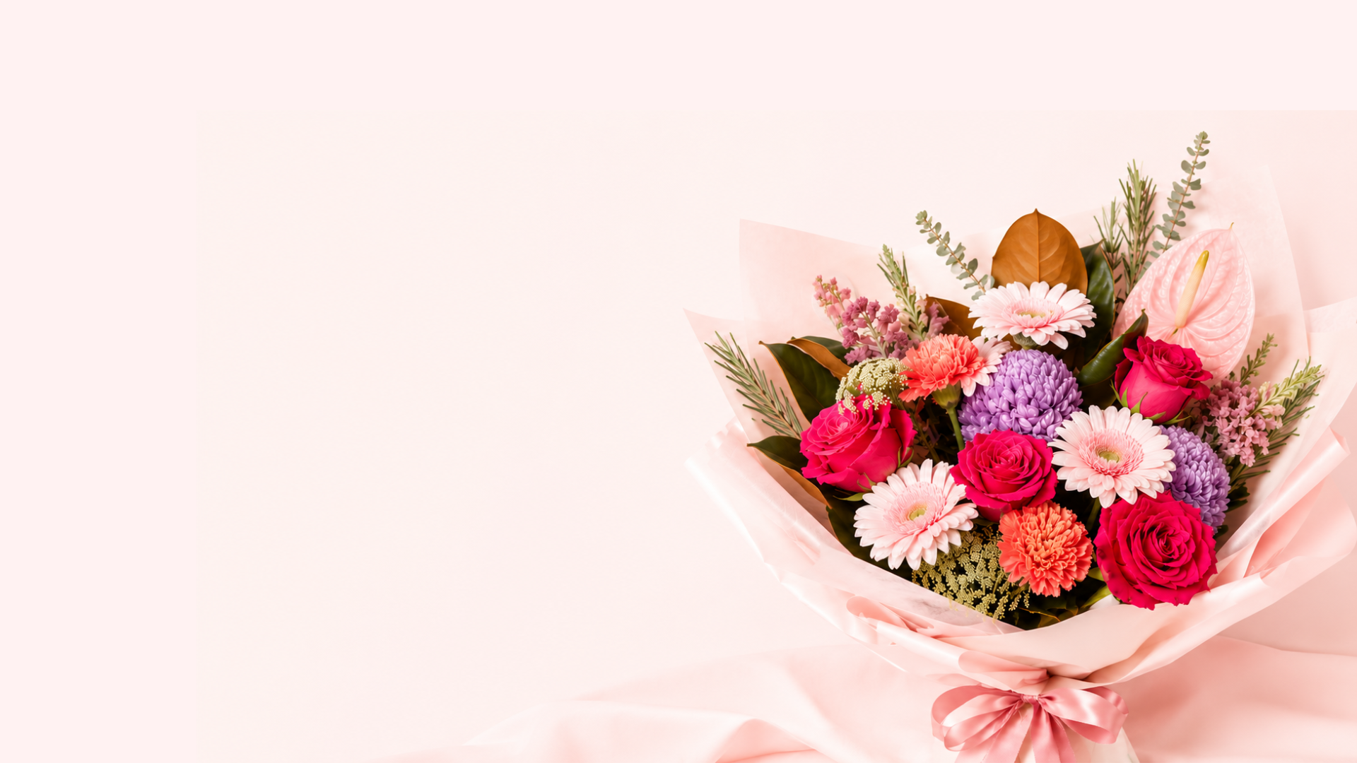 A bouquet of mixed flowers wrapped in pale pink paper and tied with a matching ribbon, placed on a light pink background. The bouquet includes pink, red, purple, white, and orange blooms with green foliage.