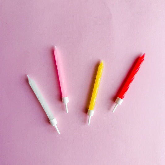Candle in pink, yellow, red, and white with holder